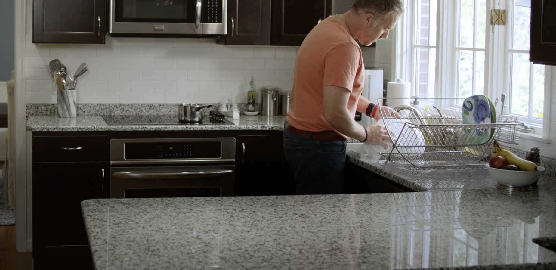 Man doing dishes in remodeled kitchen
